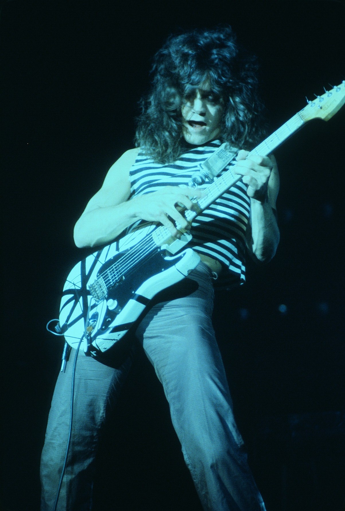A photograph of Eddie Van Halen playing electric guitar on stage.