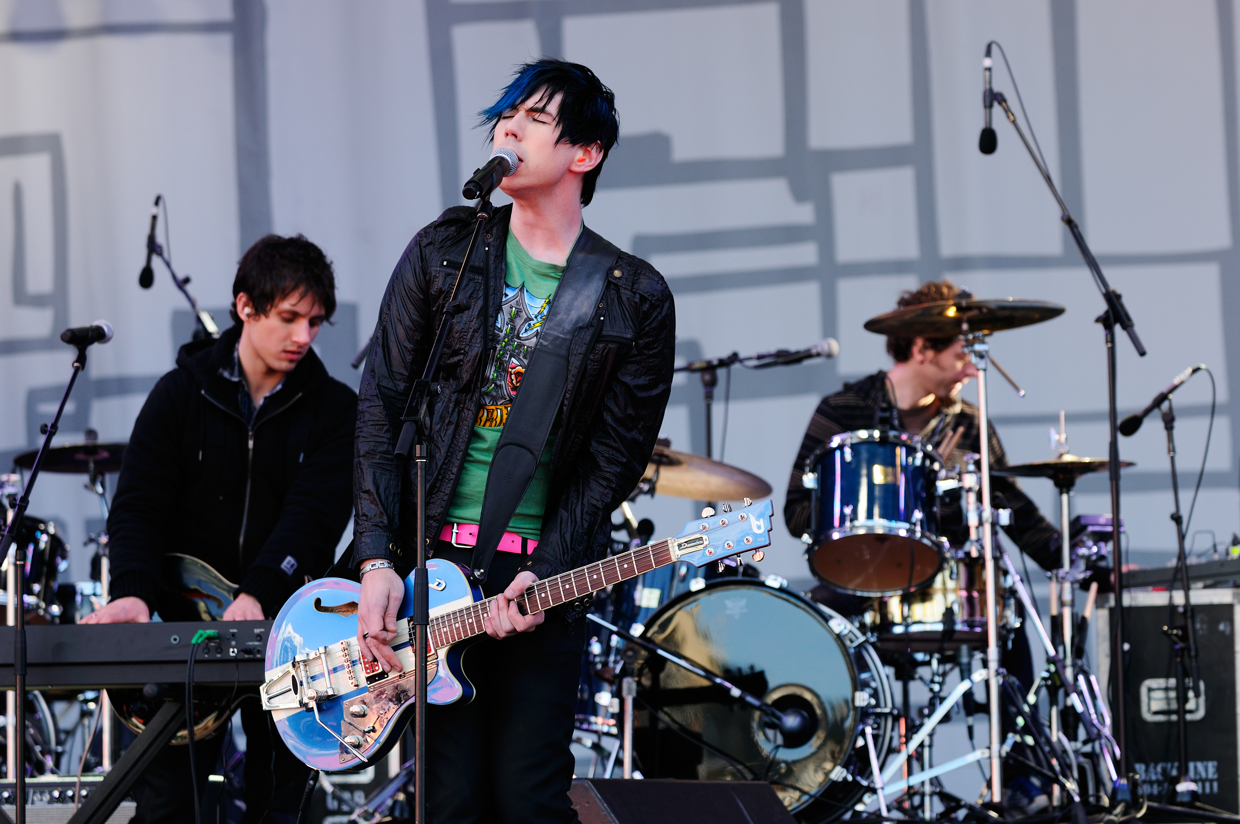 A photograph of three members of Marianas Trench performing a song on an outdoor stage.