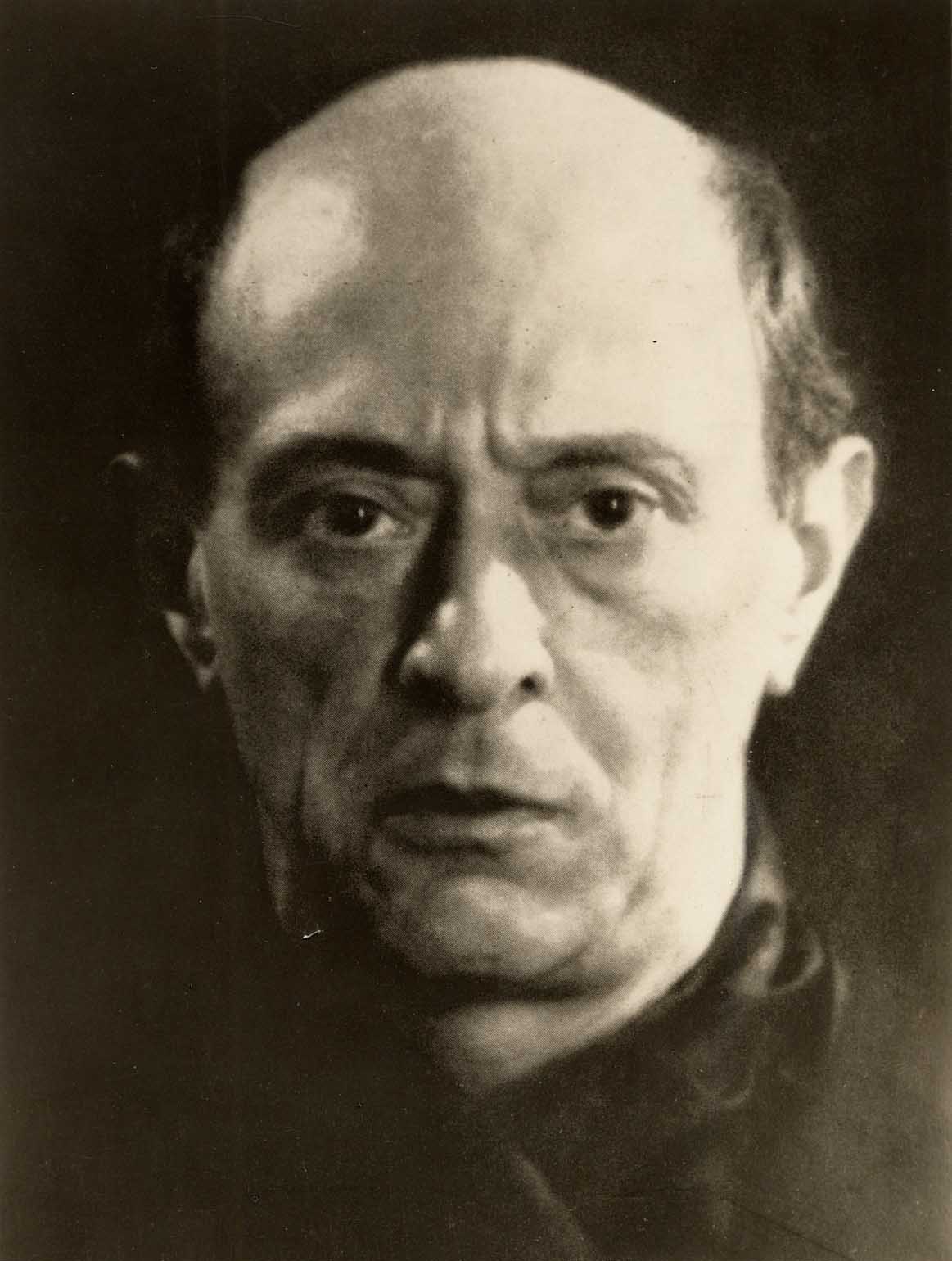 A closeup black-and-white portrait photograph of Arnold Schoenberg.